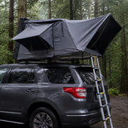 TrailNest Panorama rooftop tent in light rain at a forest campsite