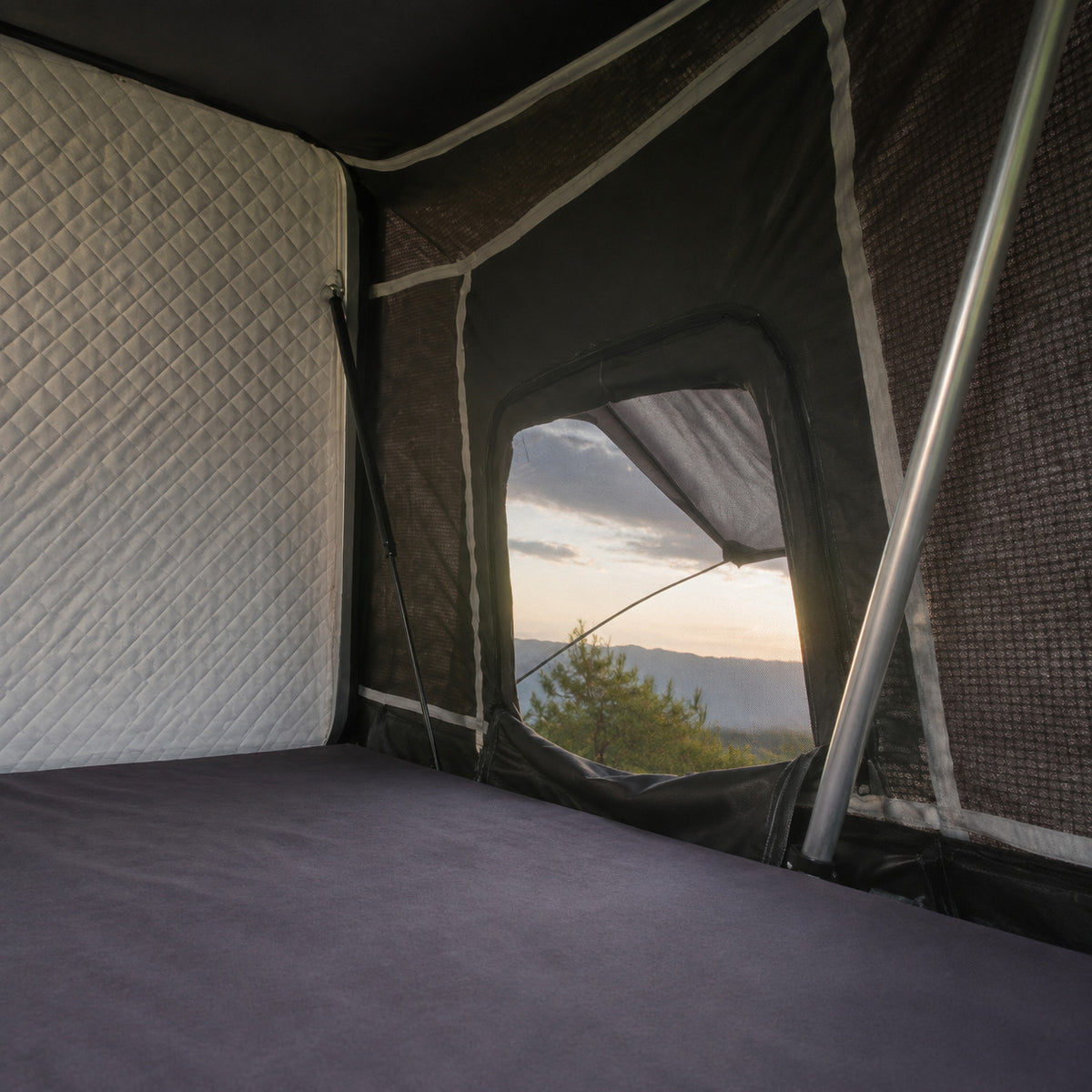 Interior view of the TrailNest Panorama rooftop tent mattress and screened window