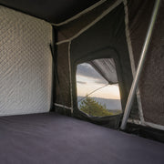 Interior view of the TrailNest Panorama rooftop tent mattress and screened window