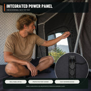 Camper using the integrated power panel inside the TrailNest Panorama rooftop tent with USB detail inset