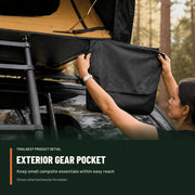 Camper attaching the exterior hanging gear pocket beside the TrailNest rooftop tent ladder