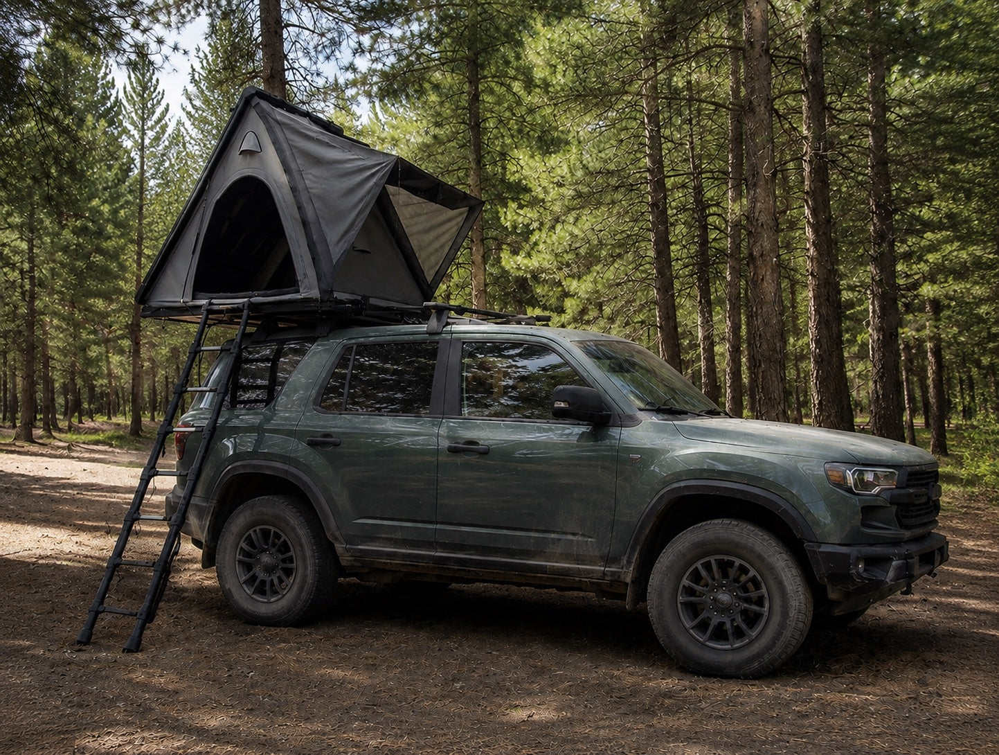 Wedge 132 hard-shell rooftop tent mounted on an SUV in a forest